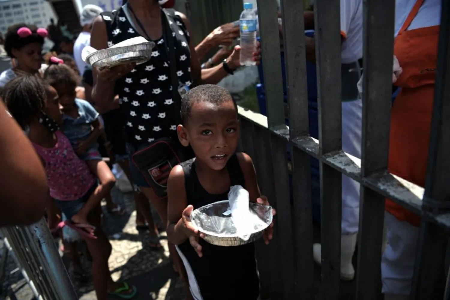 A boy receives a meal in a queue at a food distribution center in Rio de Janeiro, Brazil. (AFP)