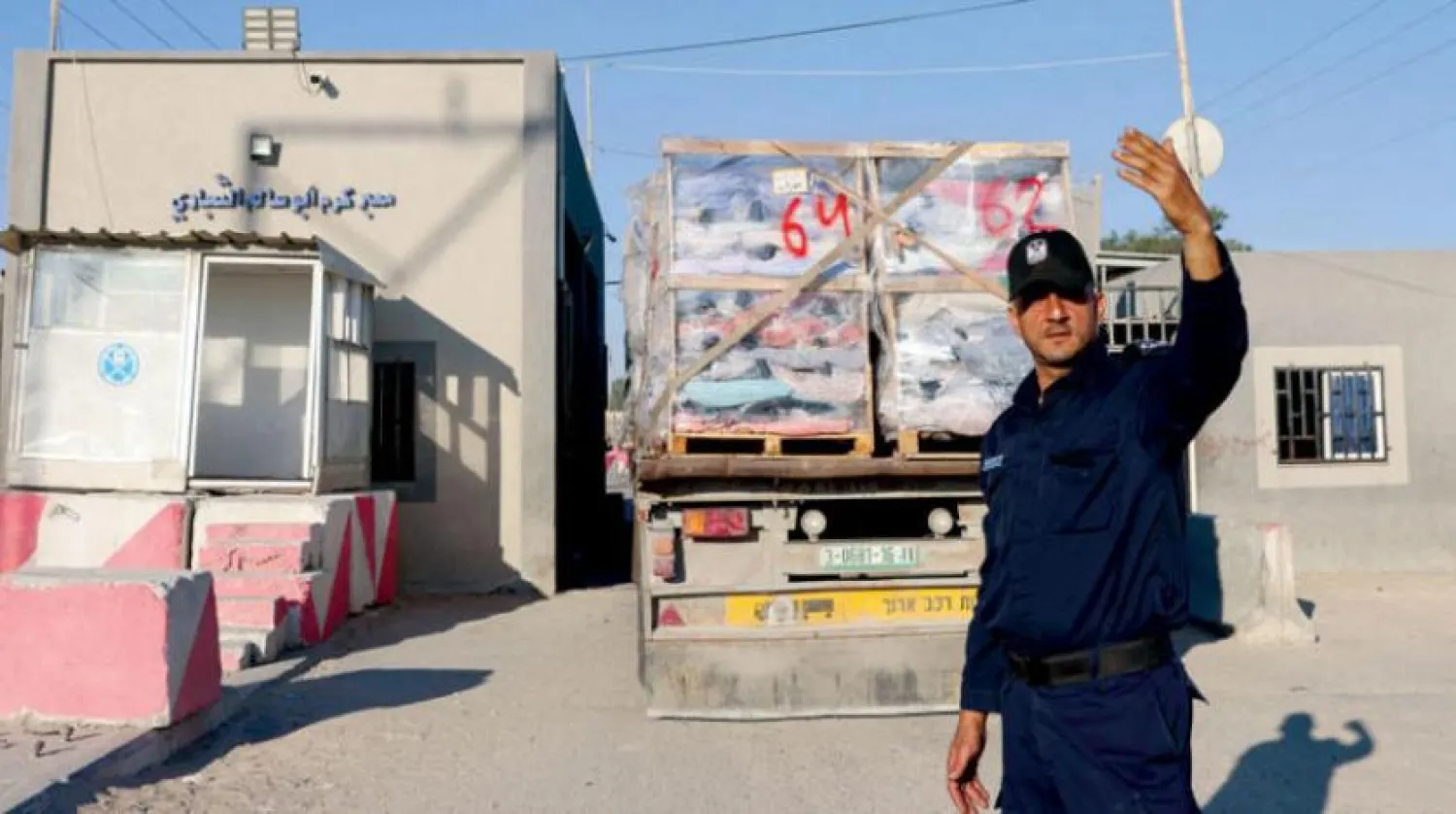A Palestinian policeman directs a truck loaded with materials intended for export at Abu Karam crossing on Monday. (AFP)
