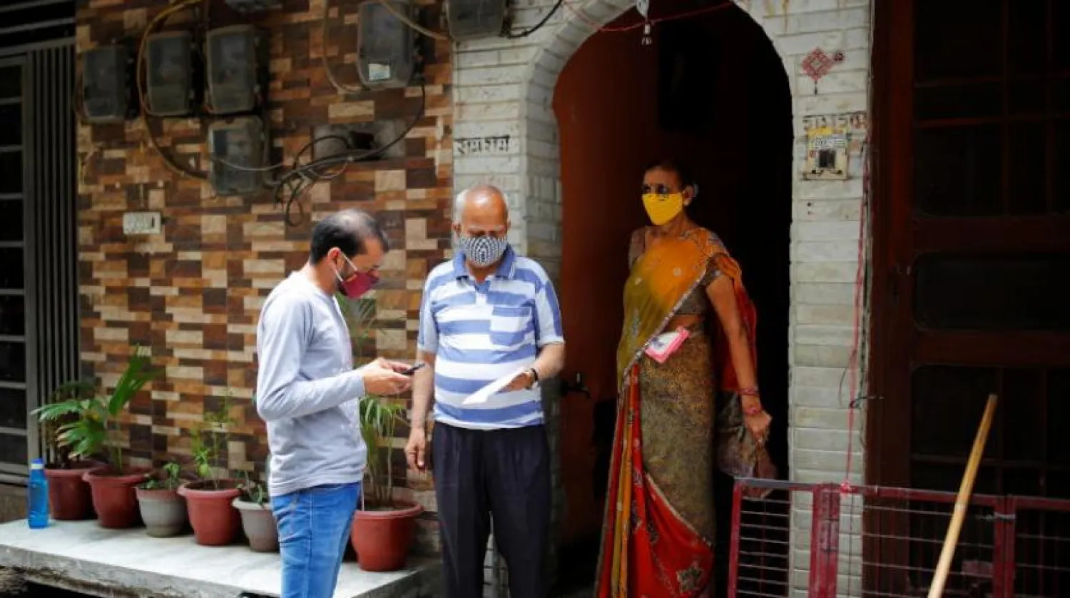 Hindistan’da bir gönüllü bir çiftin aşı için kaydolmasına yardımcı oluyor (Reuters)