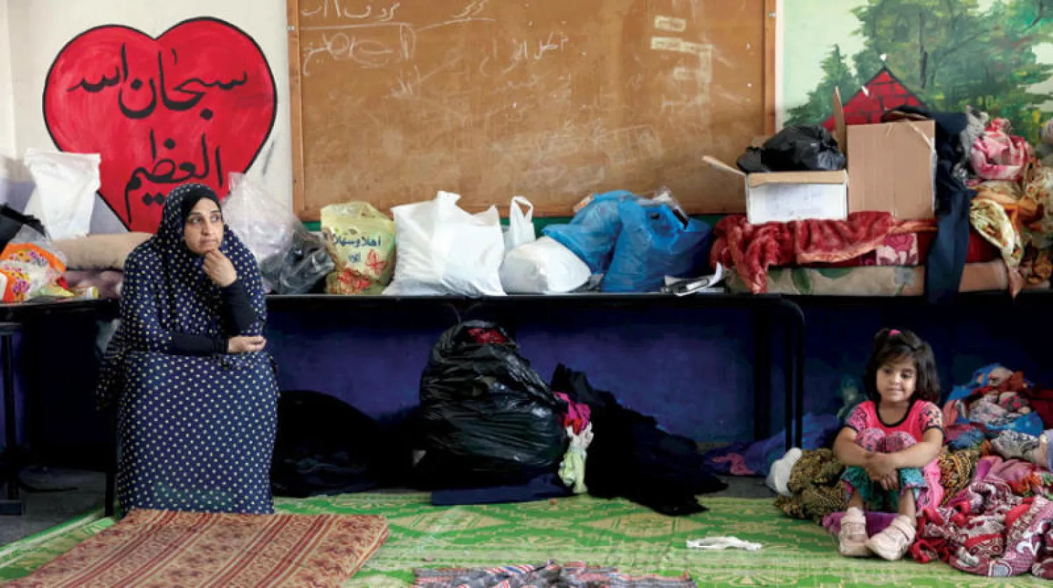 عائلة من غزة لجأت إلى مدرسة تشرف عليها الأونروا بعد دمار منزلها أثناء الغارات الإسرائيلية الأخيرة (أ.ف.ب)