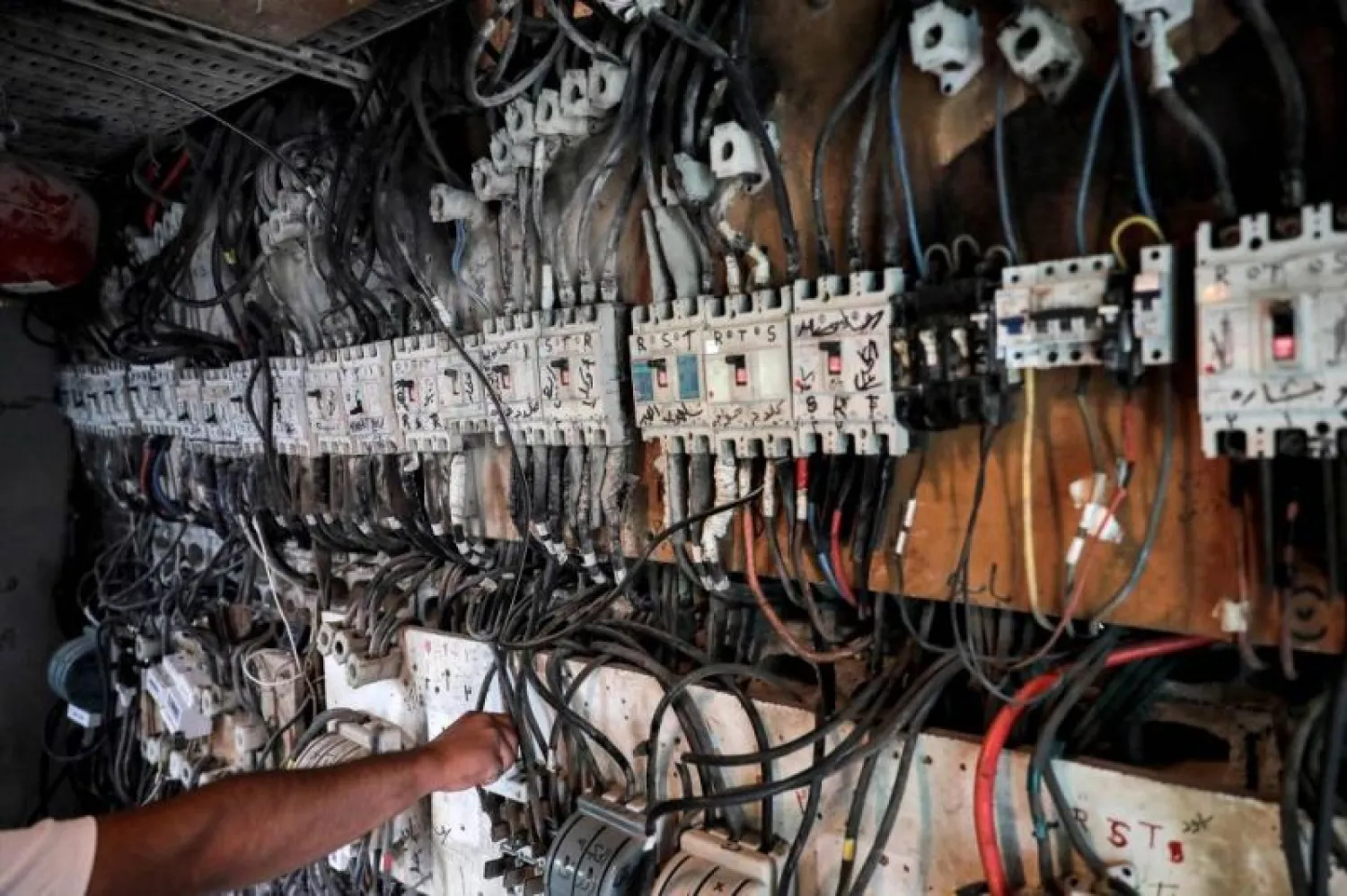 A technician controls an electric switch board connecting homes to electricity generators in a suburb of Lebanon's capital Beirut. (AFP)