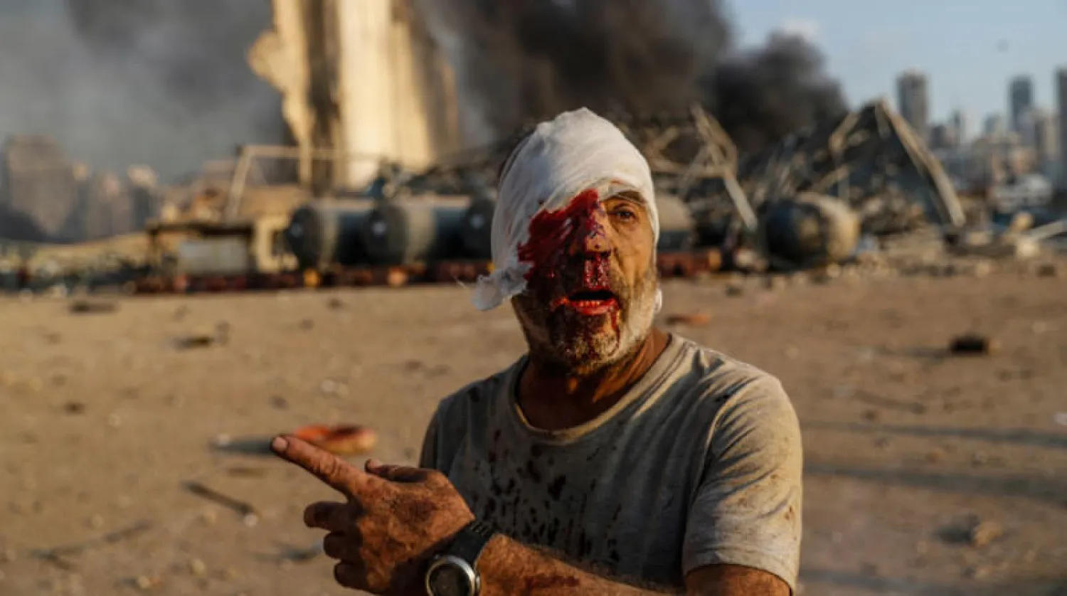 أحد المصابين أمام موقع الانفجار في مرفأ بيروت 4 أغسطس الماضي (أ.ب)