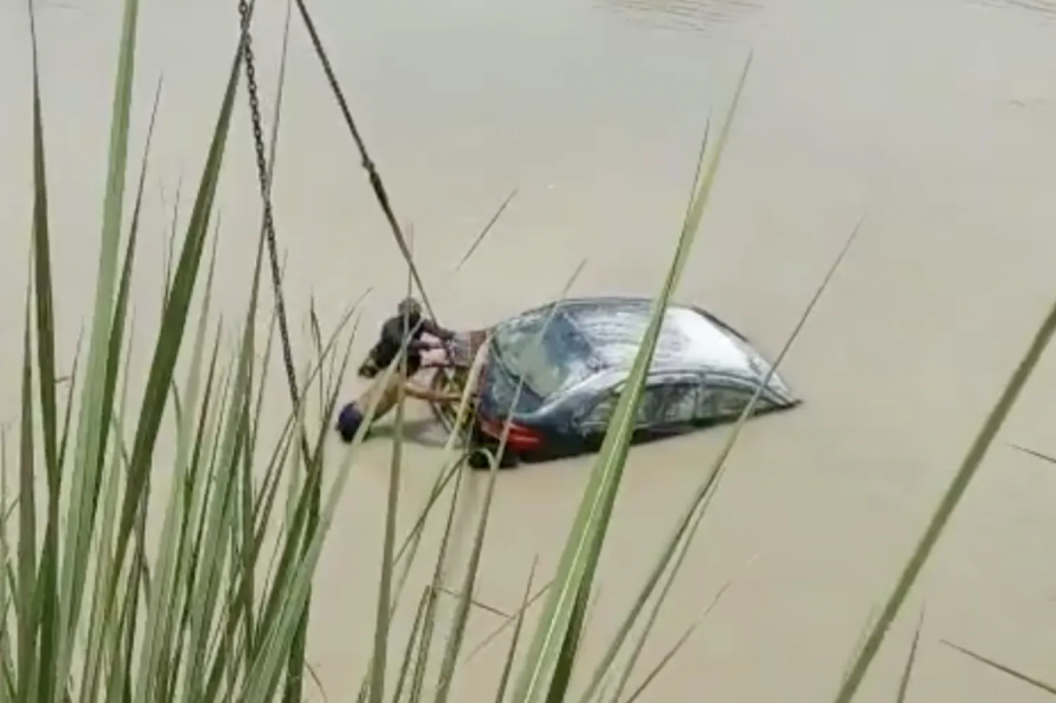 Hindistan'ın Uttar Pradeş eyaletindeki Ganj kanalından çekilerek çıkarılan otomobilin videosundan bir görüntü (Alok Pandey/Twitter)

