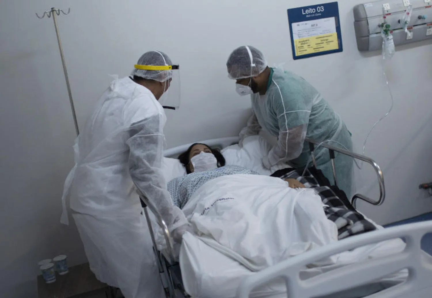 ممرضان يهتمان بمريضة مصابة بفيروس كورونا في أحد مستشفيات البرازيل (أ.ب)