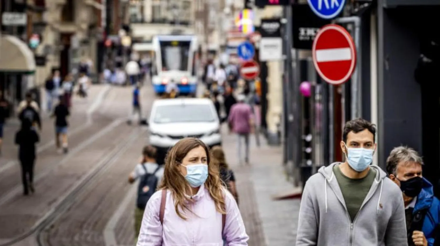 Amsterdam’da maske takan insanlar (AFP)