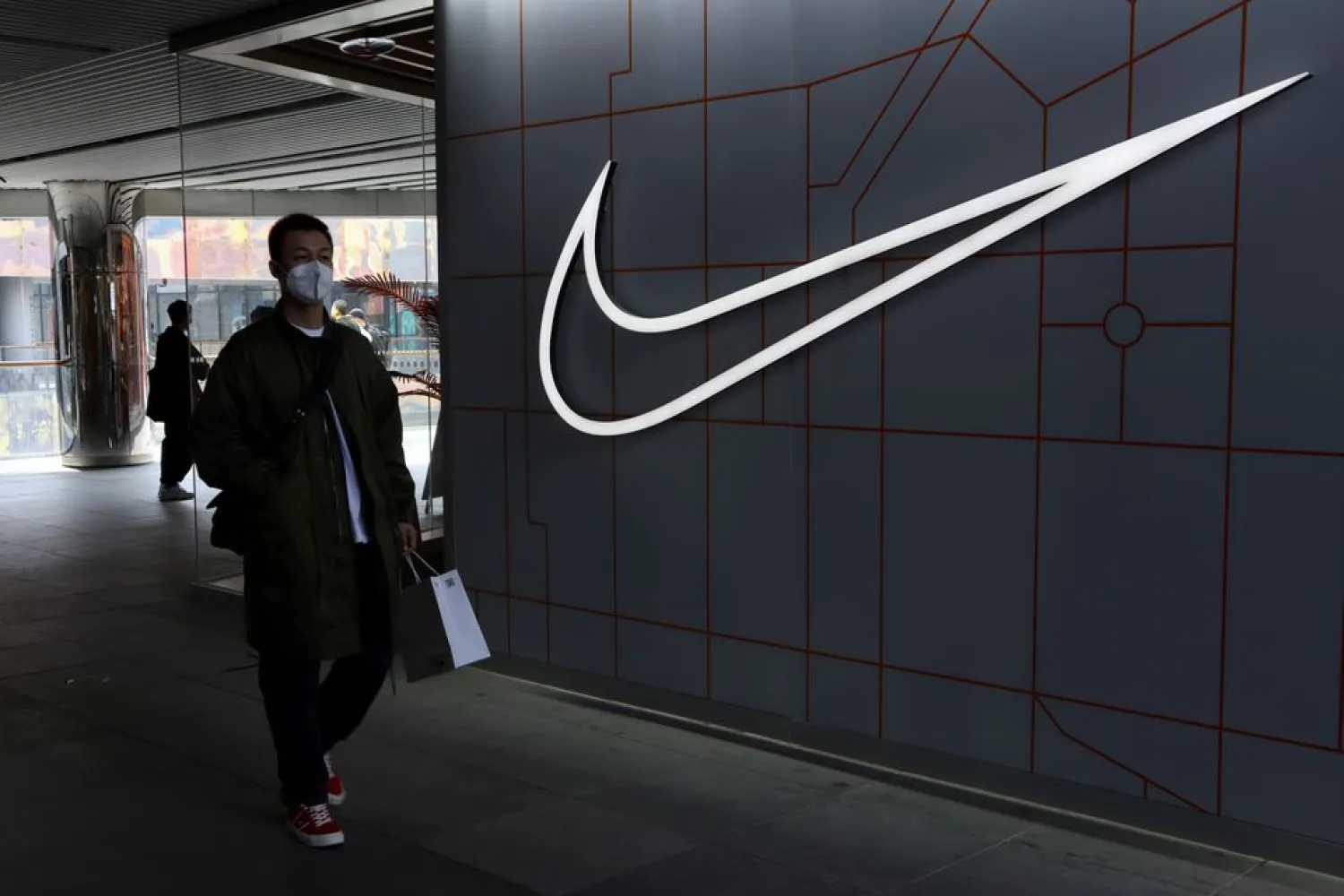 A man walks past a store of the sporting goods retailer Nike Inc at a shopping complex in Beijing, China March 25, 2021. (Reuters)