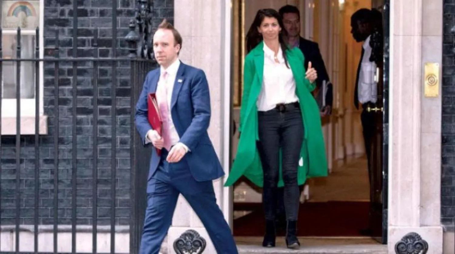 وزير الصحة البريطاني مات هانكوك ومساعدته جينا كولاد أنجلو يخرجان من مقر رئاسة الحكومة بعد إيجاز صحافي حول «كورونا» مطلع مايو الماضي (غيتي)
 *** ملحوظة:
 يرجى مراجعة العبارة التالية (وزير الصحة البريطاني مات هانكوك ومساعدته جينا كولاد أنجلو يخرجان من مقر رئاسة الحكومة بعد إيجاز صحافي حول «كورونا» مطلع مايو الماضي (غيتي))
ومرة أخرى مع الصورة