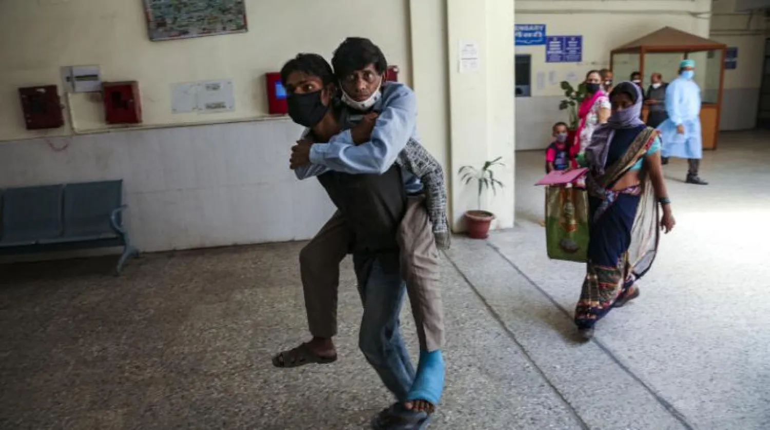 Keşmir yakınlarında bir adam arkadaşını kliniğe taşıyor (AP)