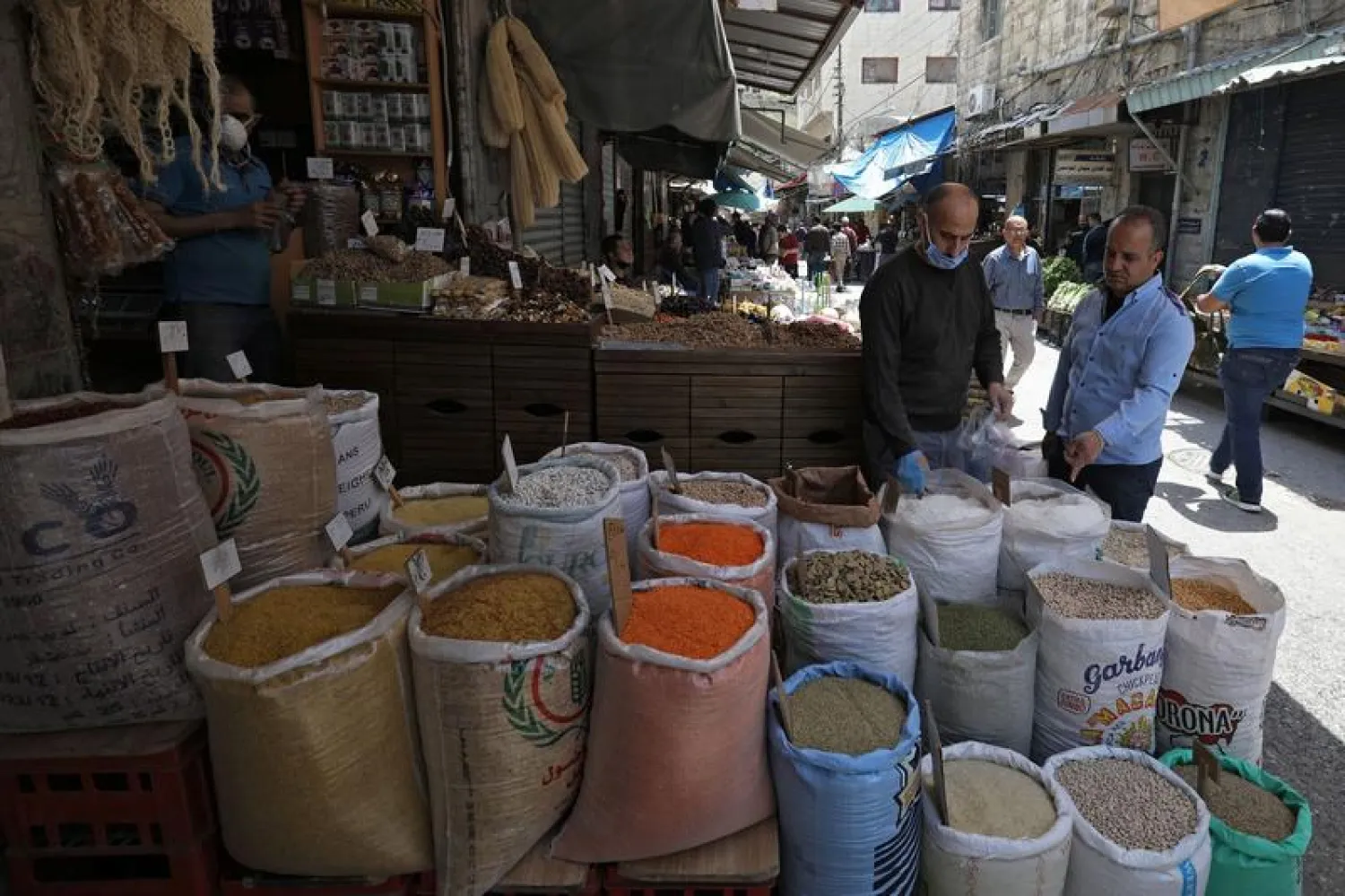 A vendor wearing a protective face mask serves customers at his shop, ahead of the Muslim holy month of Ramadan, amid concerns over the coronavirus disease (COVID-19), in Amman, Jordan April 21, 2020. REUTERS/Muhammad Hamed/File Photo
