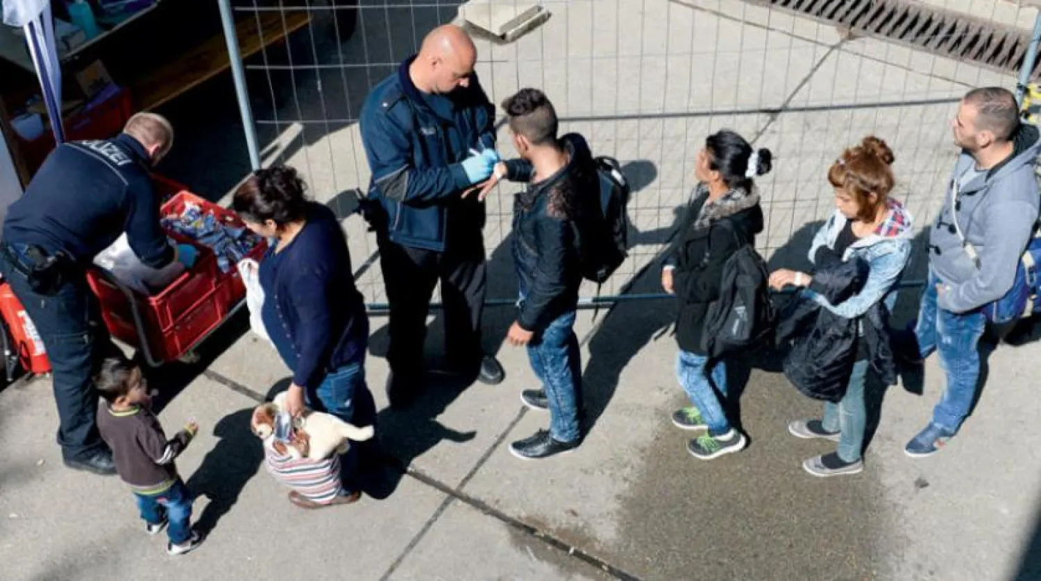 Refugees from Syria, Pakistan, and Afghanistan wait at the first registration point for migrants in southern Germany, September 2015 (Getty Images) 

