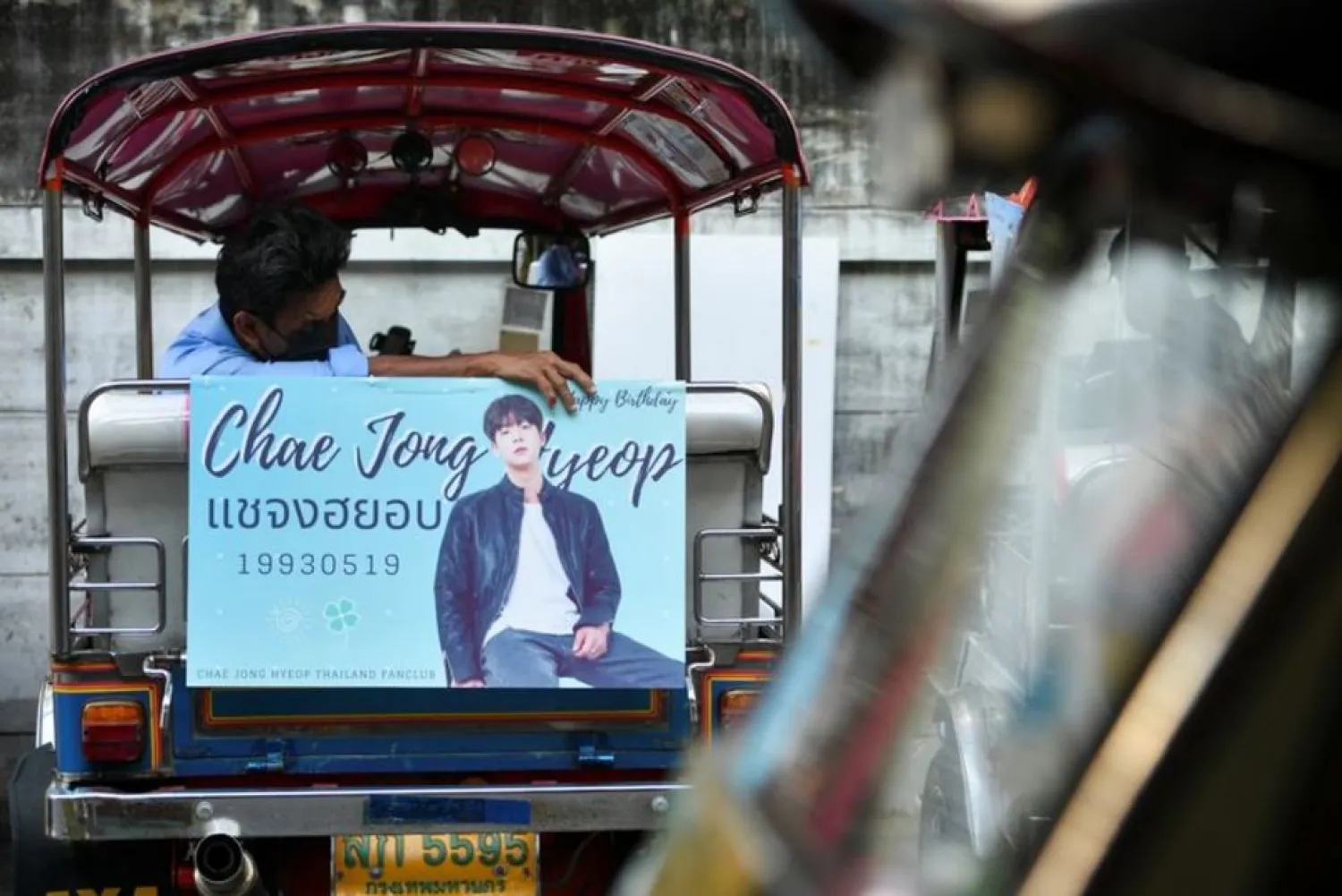 A tuk-tuk driver, with his vehicle decorated with a banner of a Korean star, waits for customers in Bangkok, Thailand May 12, 2021. (Reuters)