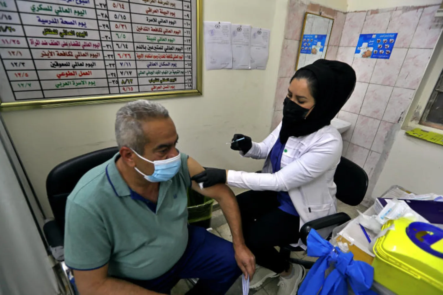 رجل يتلقى جرعة من لقاح مضاد لفيروس كورونا في بغداد (أ.ب)