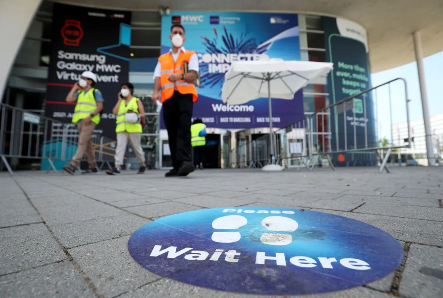Workers prepare an entrance for the Mobile World Congress (MWC) at Fira de Barcelona, in Barcelona, Spain June 25, 2021. REUTERS/Albert Gea