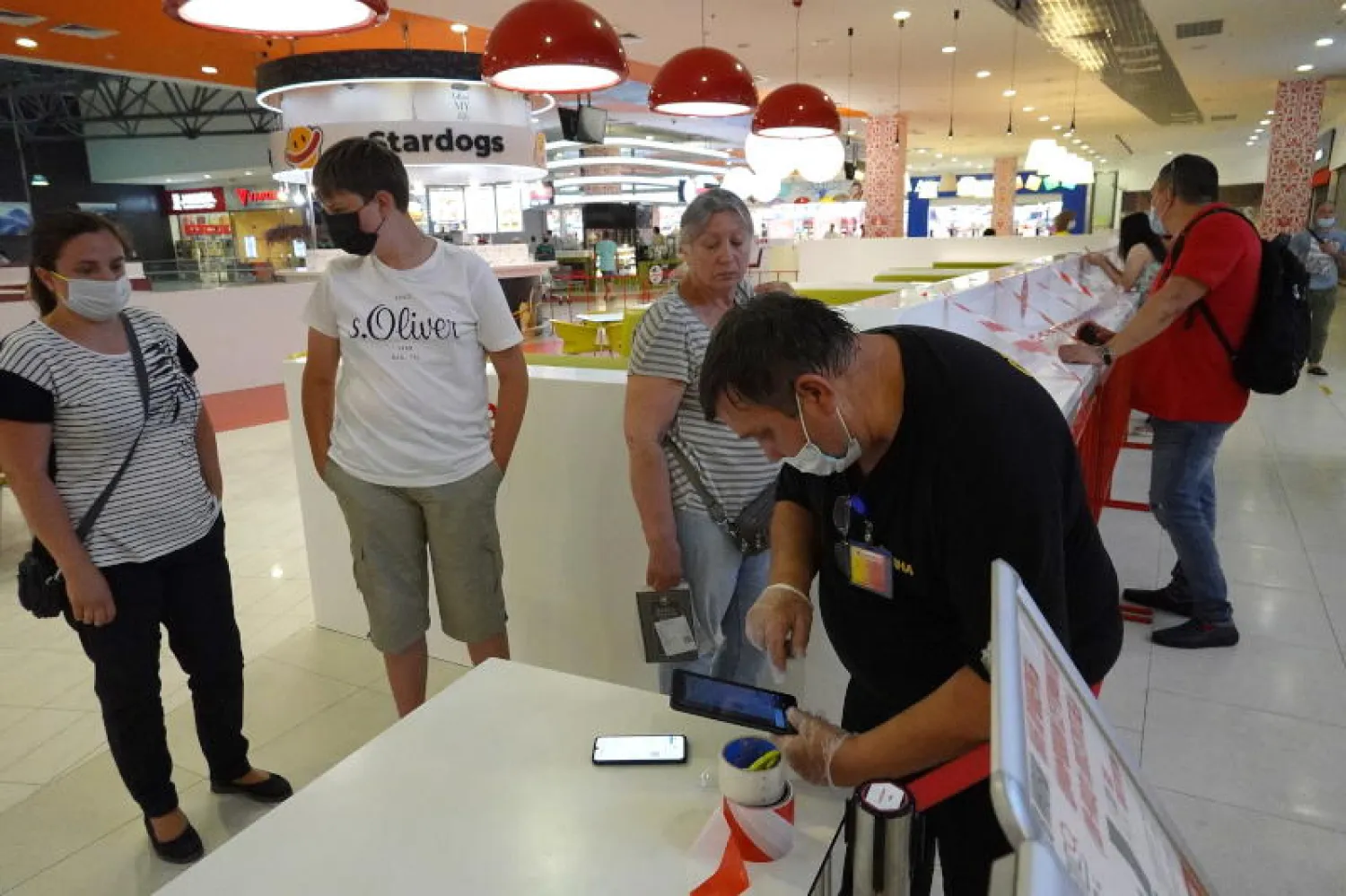 ضابط يتحقق من (كيو آر كود) لمواطنين روس والذي يفيد بحصولهم على لقاح كورونا (إ.ب.أ)