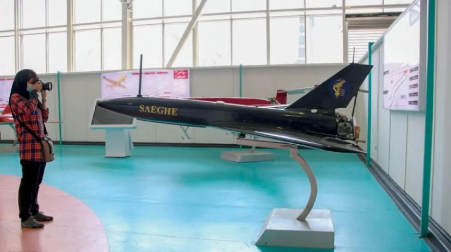 Devrim Muhafızları’na ait balistik füzelerin ve uçakların sergilendiği bir fuarda ‘Saike' (Yıldırım) adlı insansız hava aracının (İHA) fotoğrafını çeken İranlı bir kadın (Mehr)