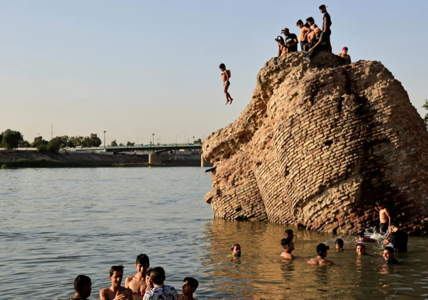 عراقيون يلجأون إلى مياه نهر دجلة للهروب من القيظ في بغداد (رويترز)