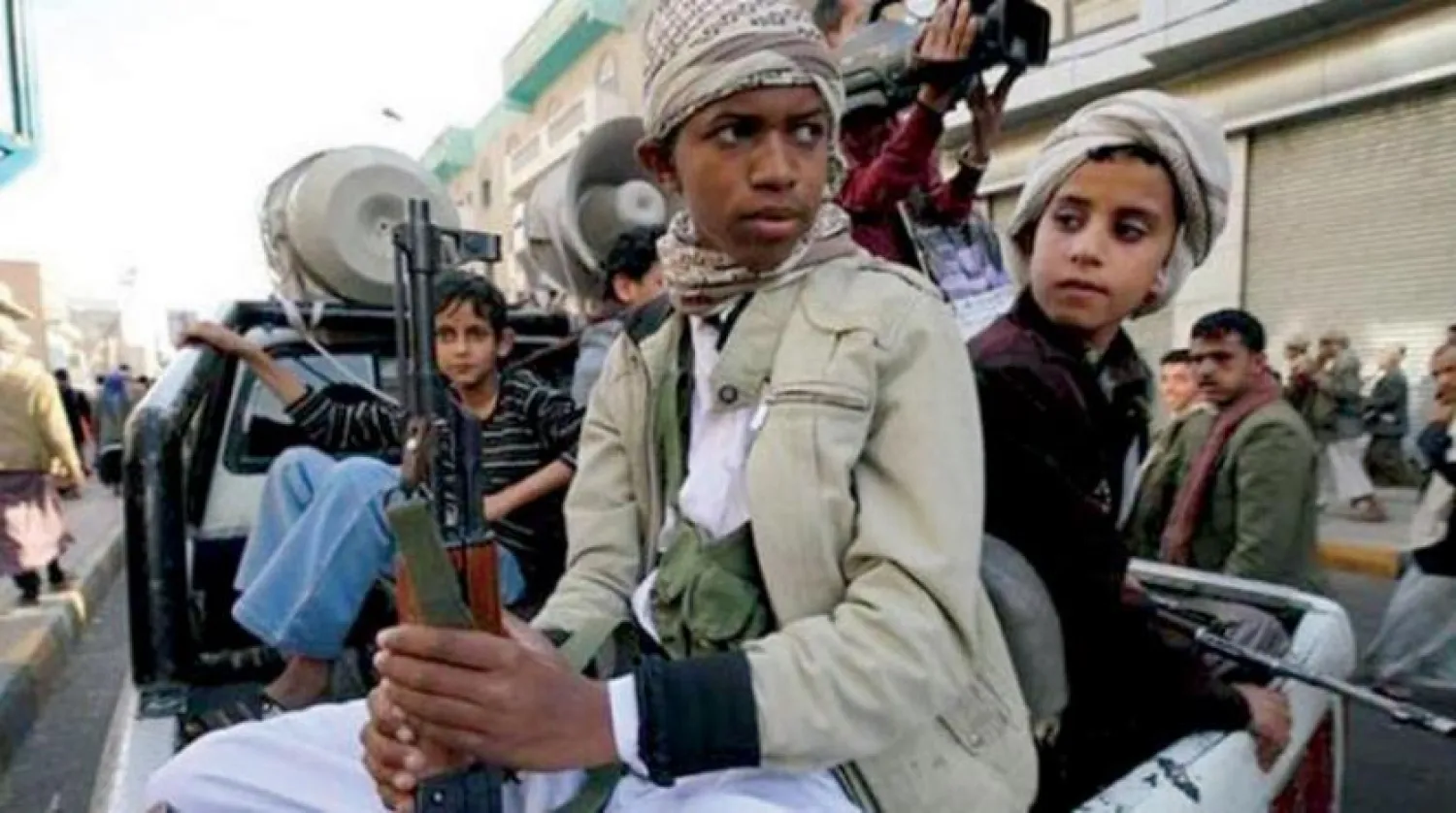 Children carrying weapons beside Houthi fighters in Sanaa (Reuters)
