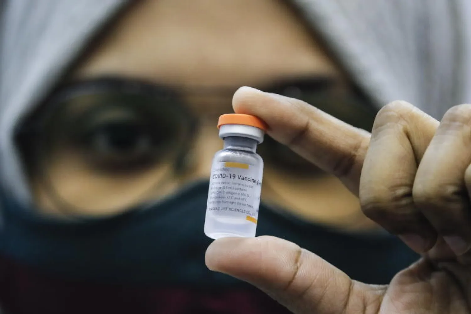 ممرضة تحمل جرعة من لقاح سينوفاك الصيني (إ.ب.أ)