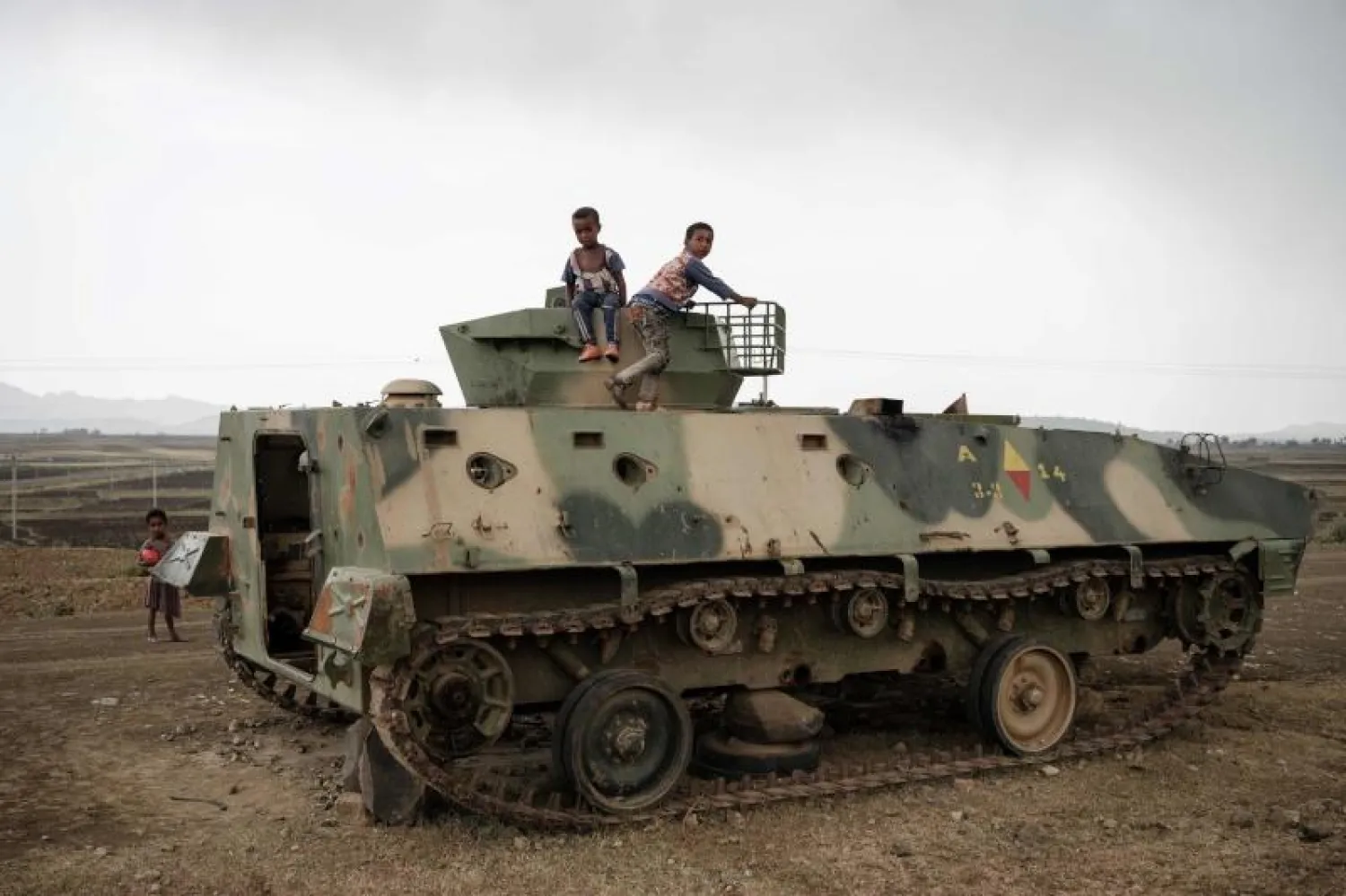 أطفال يلعبون على دبابة تابعة للقوات الحكومية الإثيوبية بالقرب من ميكيلي (أ.ف.ب)