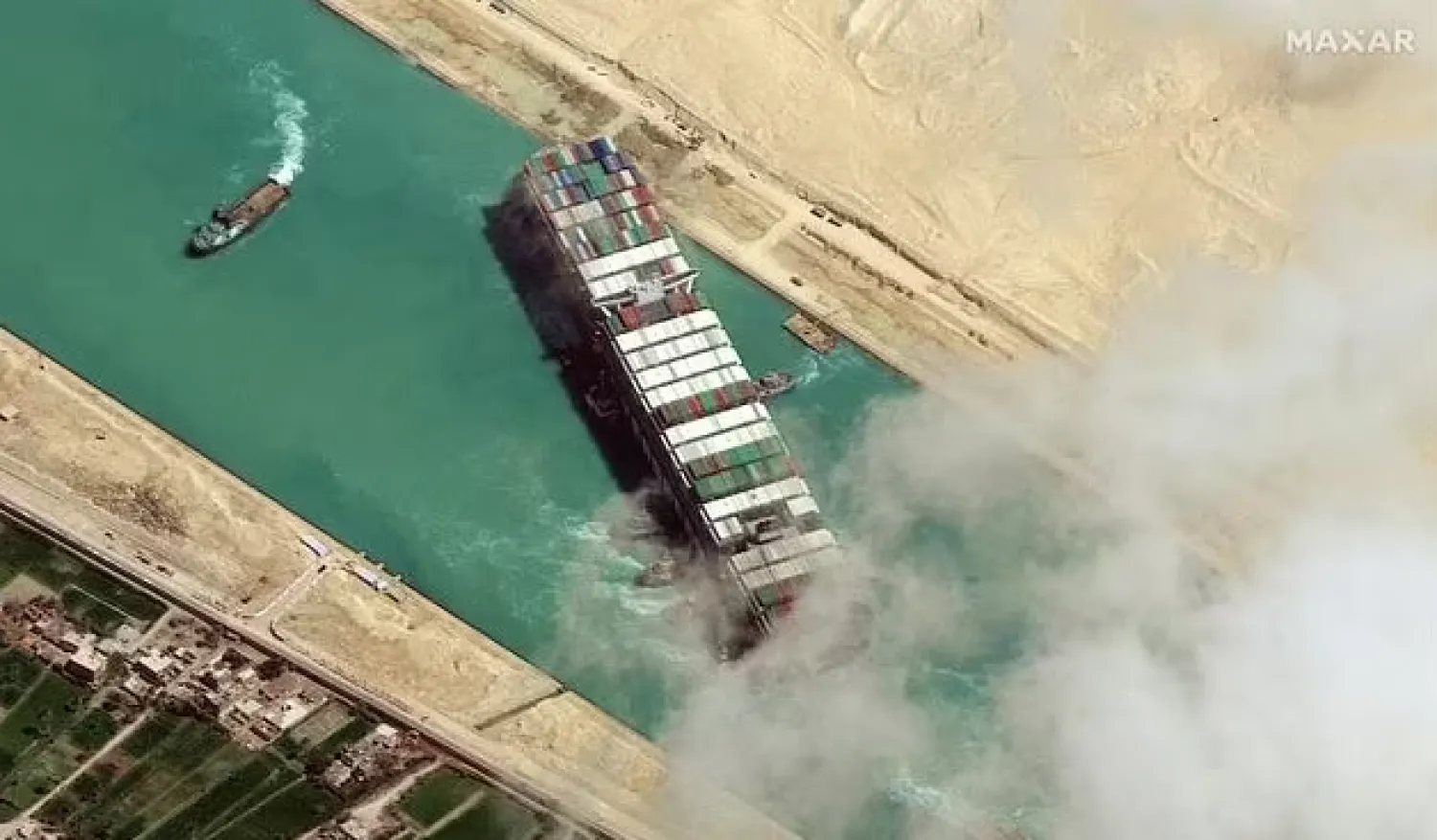 (FILES) In this file satellite imagery released by Maxar Technologies on March 29, 2021 the MV Ever Given container ship being pushed by tugboats in the Suez Canal. AFP