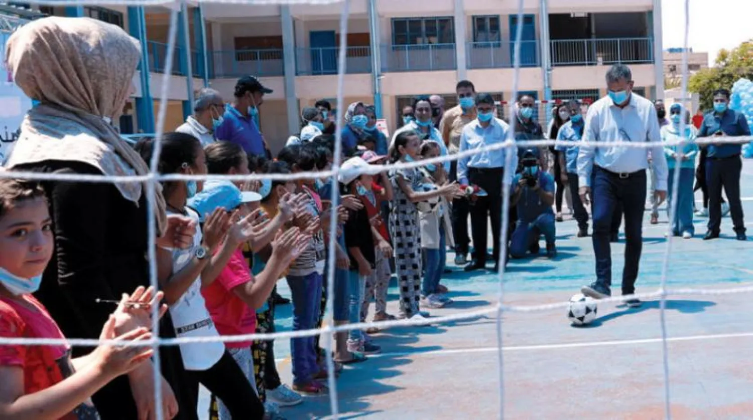 Commissioner-General of UNRWA, Philippe Lazzarini, plays soccer with students at the summer schools in Gaza (AP)