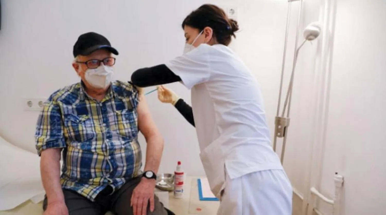 Almanya'nın Berlin kentinde yaşlı bir vatandaşa aşı yapılıyor. (Reuters)