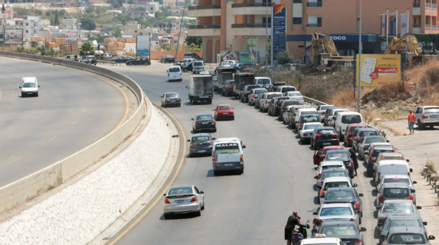سيارات تنتظر قرب إحدى محطات البنزين على الطريق بين صيدا وبيروت (رويترز)