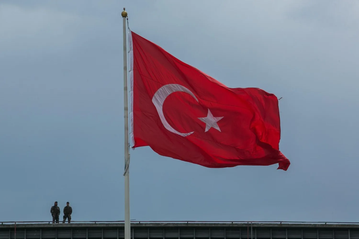 Turkish soldiers stand near a Turkish flag in Istanbul on May 1, 2017. (AFP)