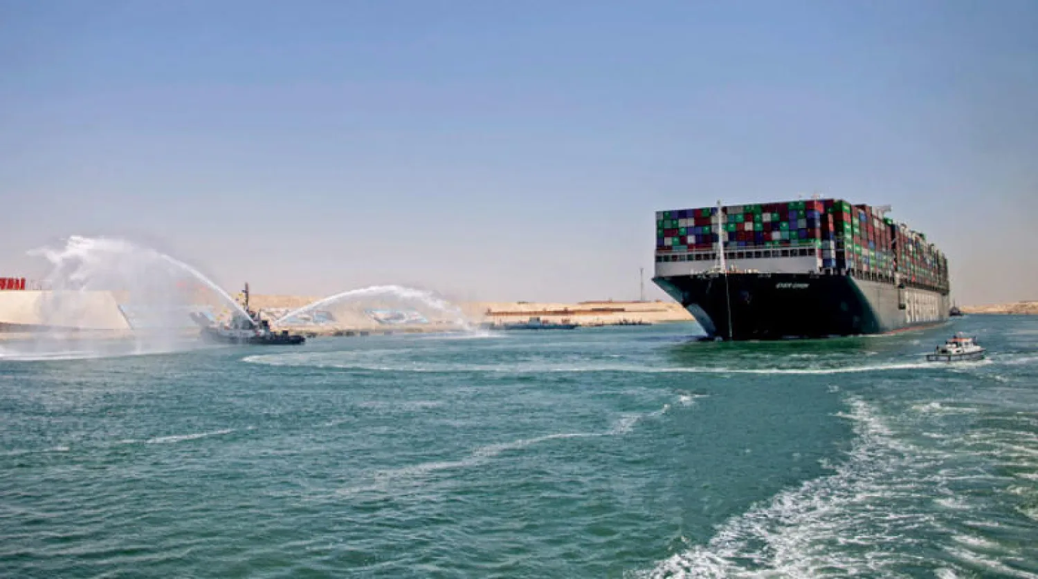 ناقلة الحاويات الضخمة «إيفر غيفن» خلال بدء تحركها من مقر احتجازها عقب اتفاق التسوية مع قناة السويس أمس (أ.ف.ب)