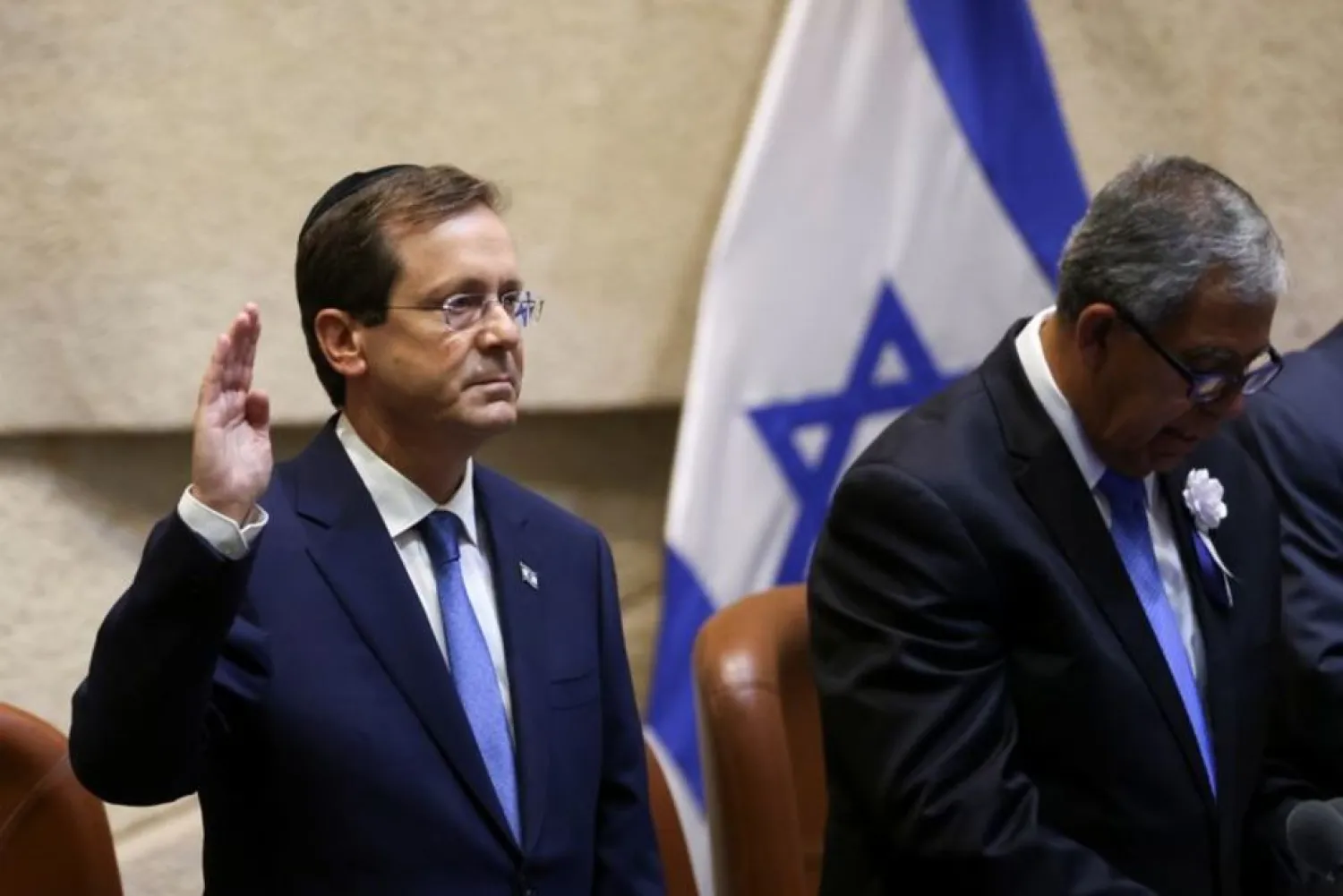 Israeli President-elect Isaac Herzog gestures next to Chairman of the Knesset Mickey Levy during a swearing-in ceremony at the Knesset, Israeli parliament, in Jerusalem July 7, 2021. (Reuters)