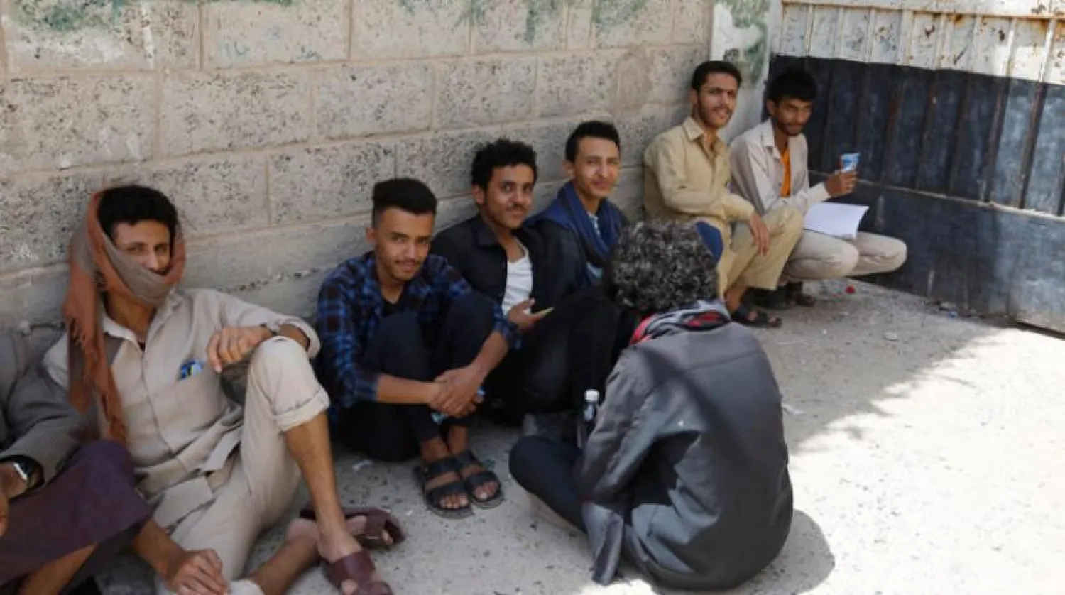 Yemeni schoolchildren wait for their classmates outside a school in Sanaa. EPA