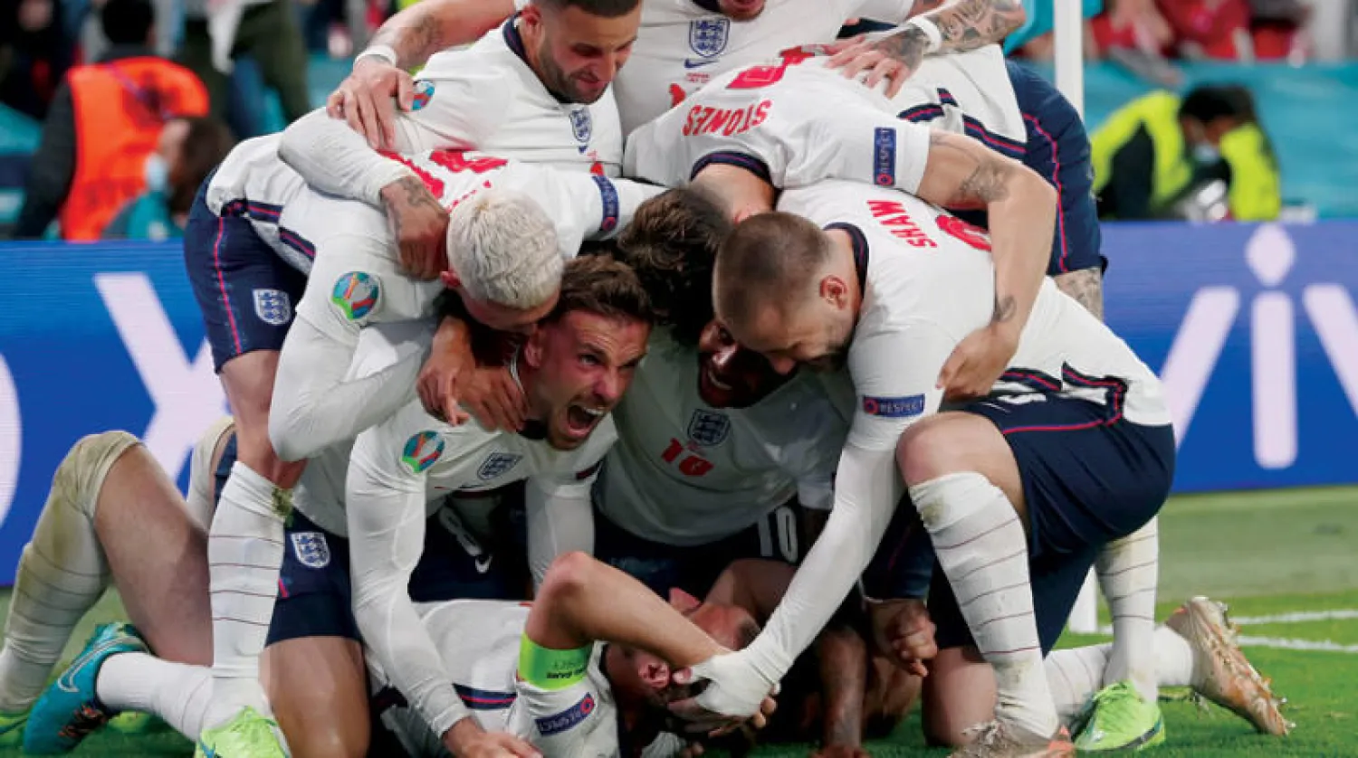 لاعبو إنجلترا يحتفلون بهاري كين (على الأرض) مسجل هدف الانتصار على الدنمارك (أ.ب)