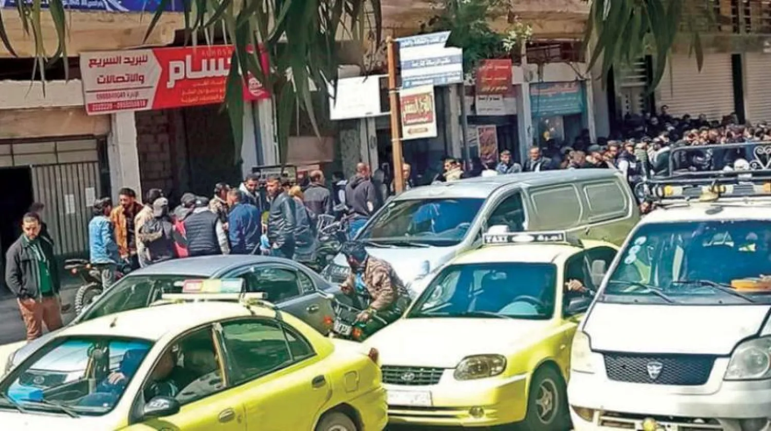 Seyahat izni almak için Dera'daki askerlik bürosunun önünde toplanan gençler (Şarku’l Avsat)