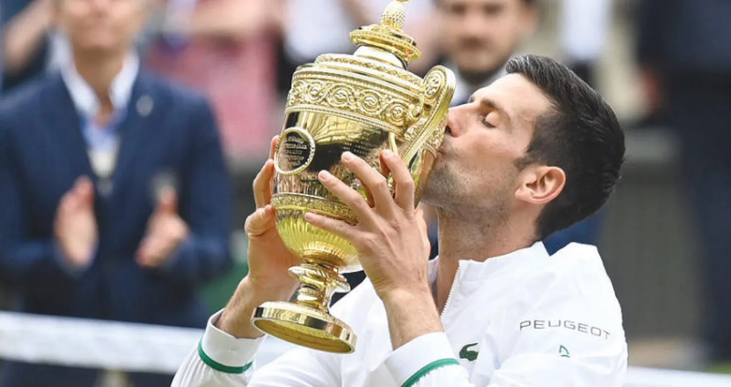 ديوكوفيتش يقبل كأس «ويمبلدون» خلال التتويج أمس (رويترز)