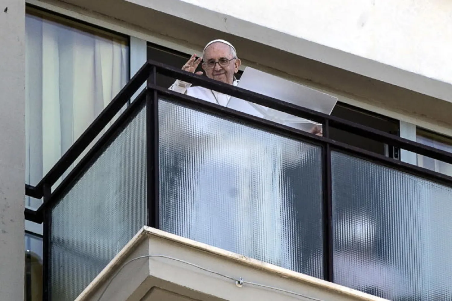 البابا فرنسيس يخرج من شُرفة أحد المستشفيات التي خضع فيها لعملية جراحية (إ.ب.أ)