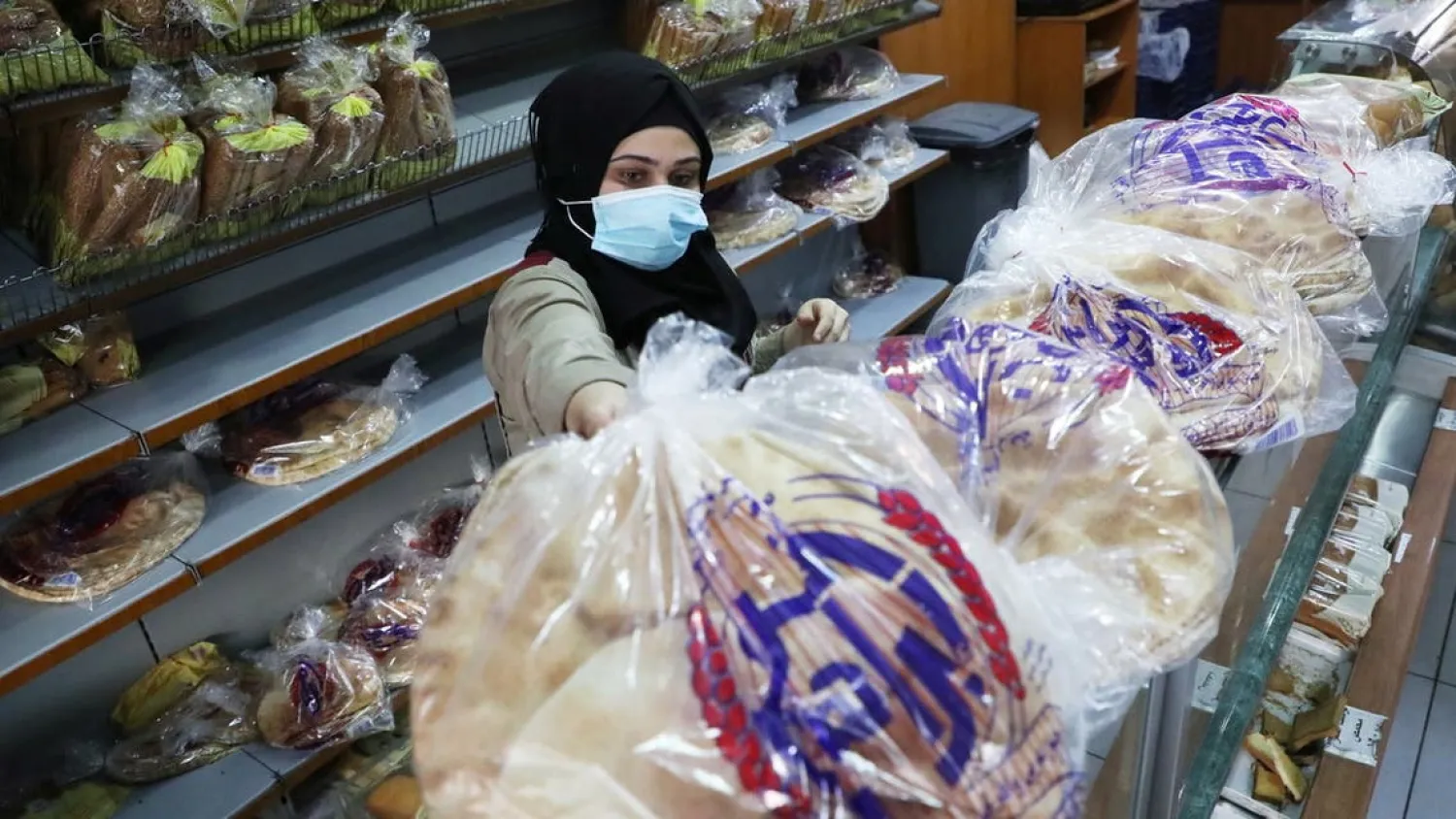 A vendor wearing a face mask arranges bread for sale inside a bakery in Beirut, Lebanon December 7, 2020. (Reuters)

