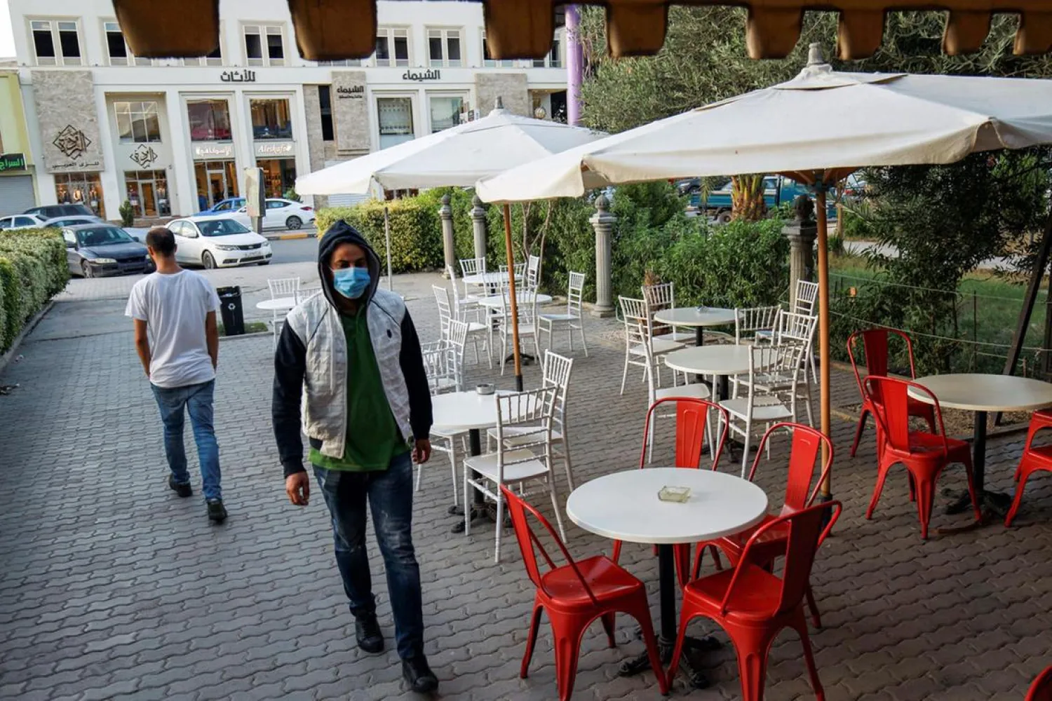 A man, mask-clad due to the COVID-19 coronavirus pandemic, walks past empty tables at a cafe in Libya's eastern city of Benghazi. (AFP)