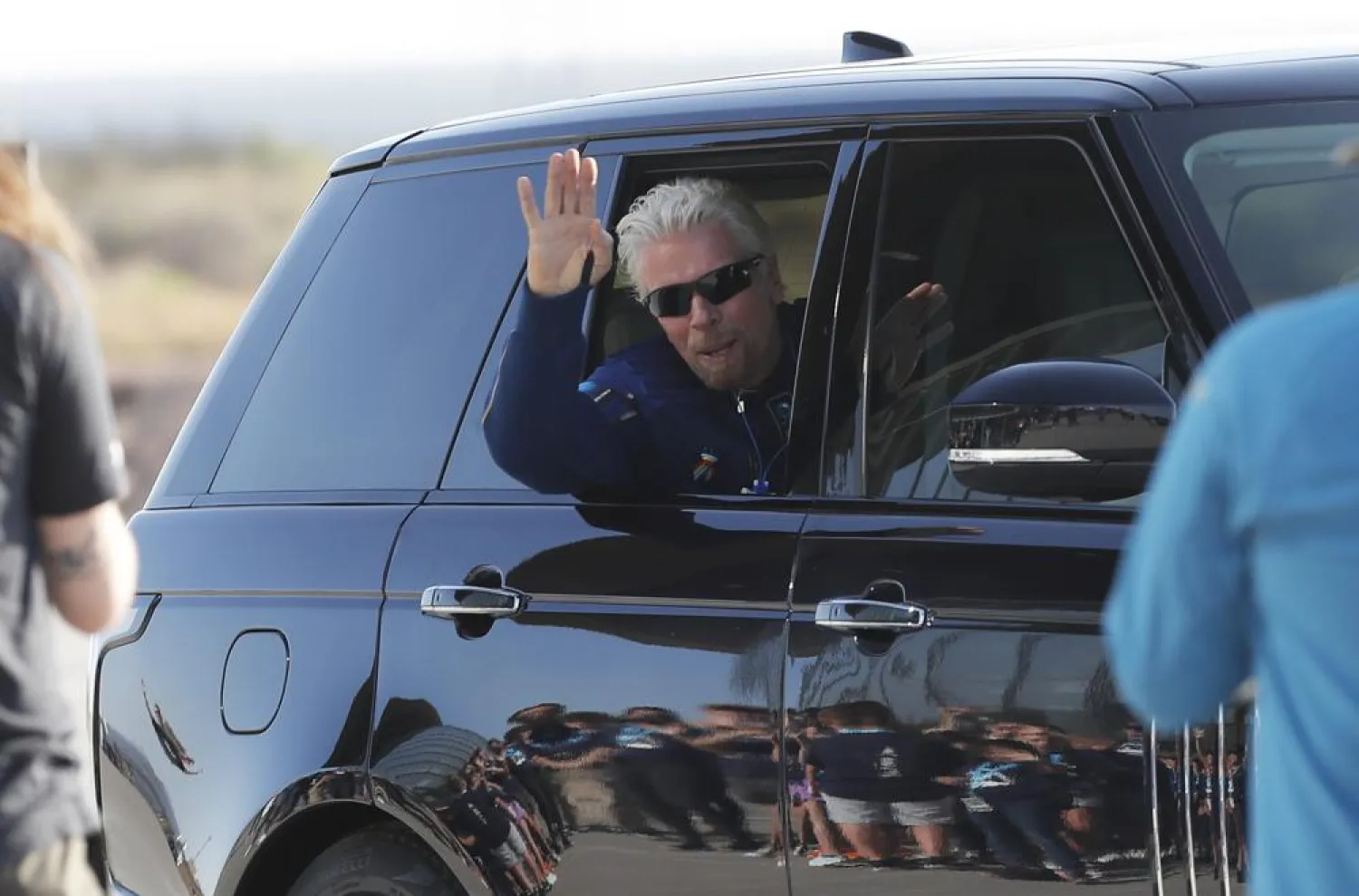 Richard Branson waves good bye while heading to board the rocket plane that will fly him to space from Spaceport America near Truth or Consequences, New Mexico, Sunday, July 11, 2021. (AP)