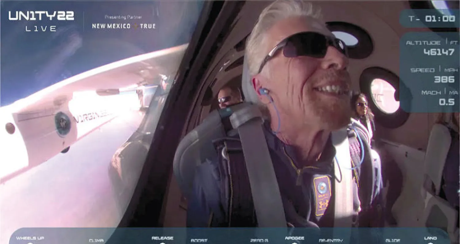 الملياردير ريتشارد برانسون يبتسم على متن مركبته الفضائية الخاصة (رويترز)