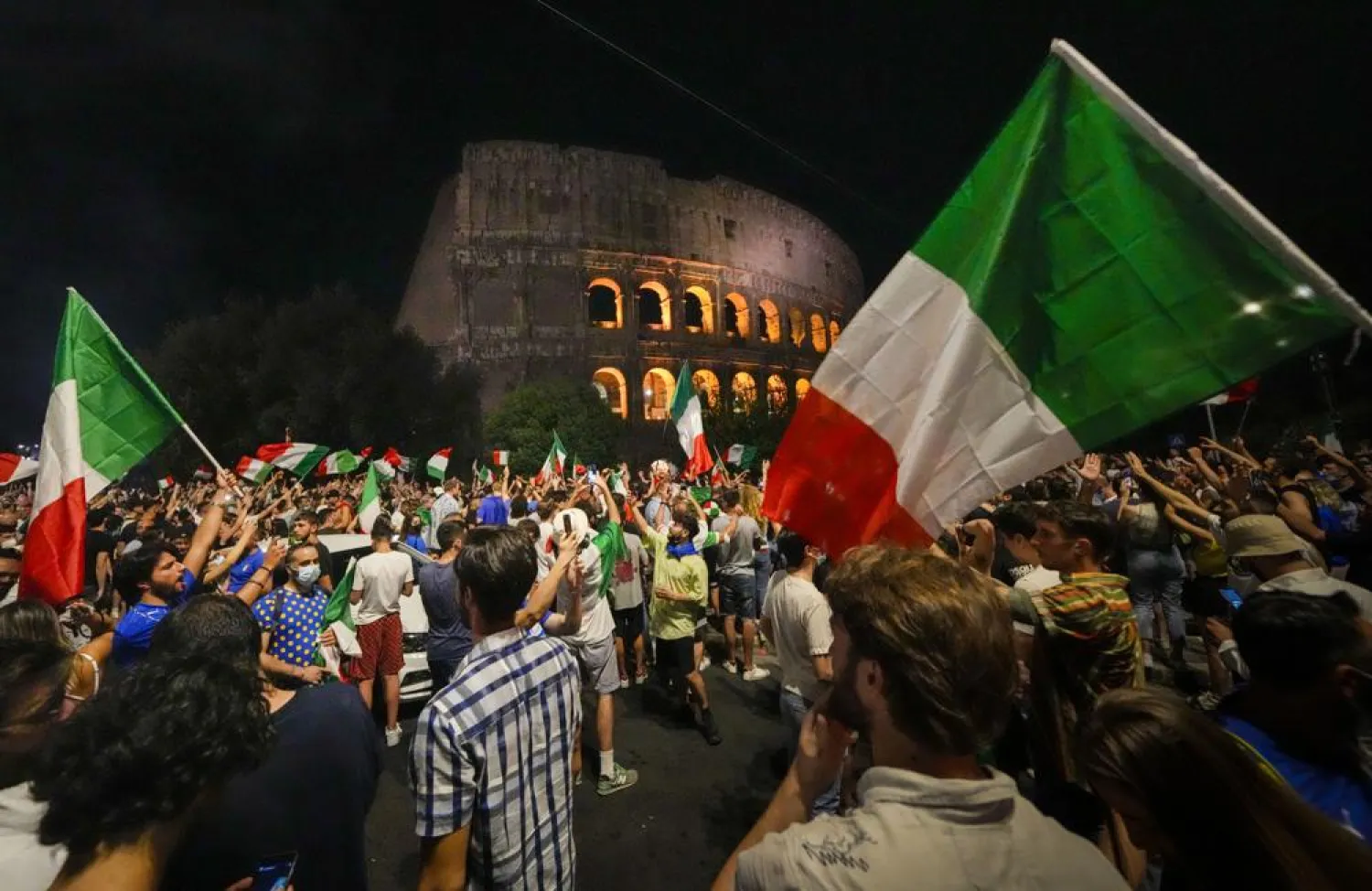 Italy's fans celebrate in front of the ancient Colosseum in Rome, Monday, July 12, 2021, after Italy beat England to win the Euro 2020 final played at Wembley stadium in London. (AP)