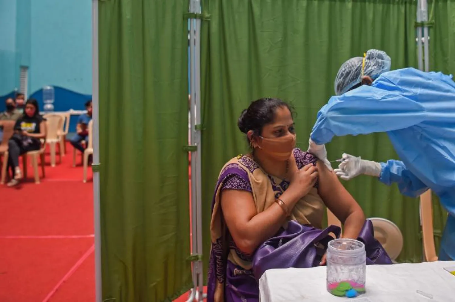 سيدة هندية تتلقى جرعة من لقاح كورونا في مومباي (أ.ف.ب)