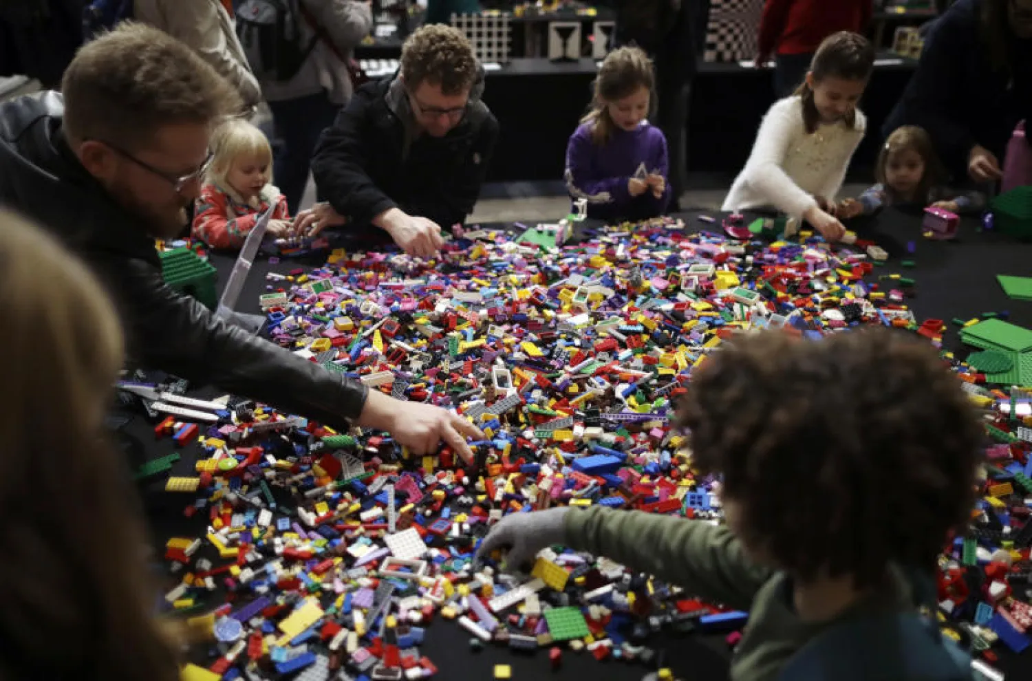 أطفال وآباء يلعبون بلعبة ليغو الشهيرة (أ.ب)