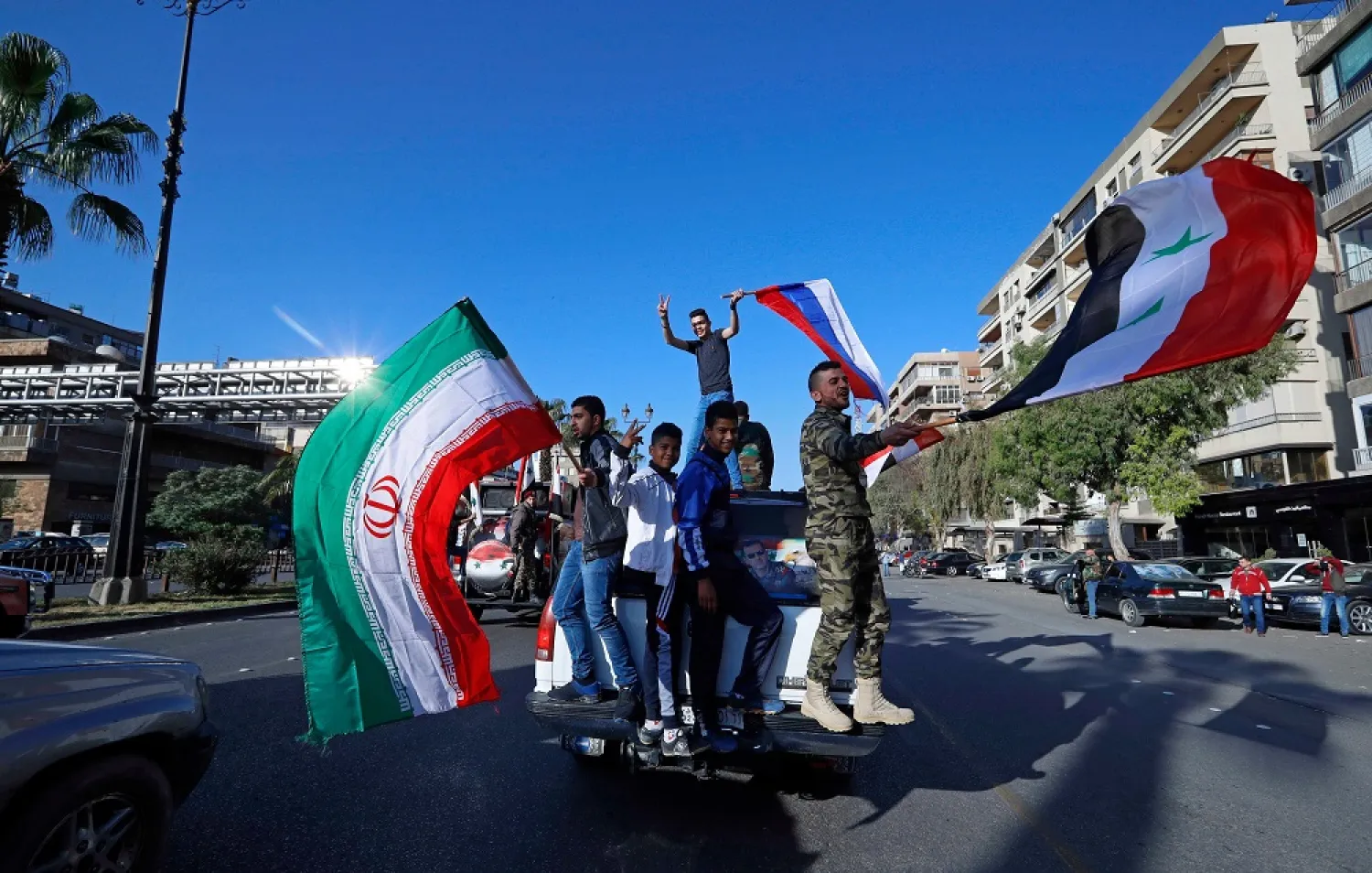 Hundreds of Syrians flash victory signs, honk car horns and wave Syrian, Iranian and Russian flags in Damascus, Syria, April 14, 2018. (AP)