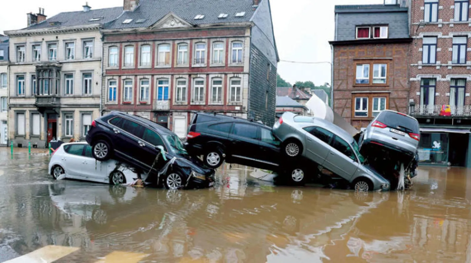 سيارات مكدسة بمدينة فيرفيرز البلجيكية بعد هطول أمطار غزيرة وفيضانات اجتاحت غرب أوروبا (أ.ف.ب)