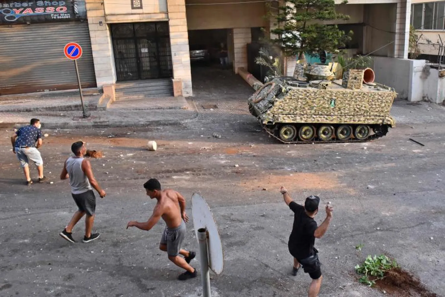 محتجون يرشقون مدرعة للجيش اللبناني بالحجارة في بيروت (أ.ف.ب)