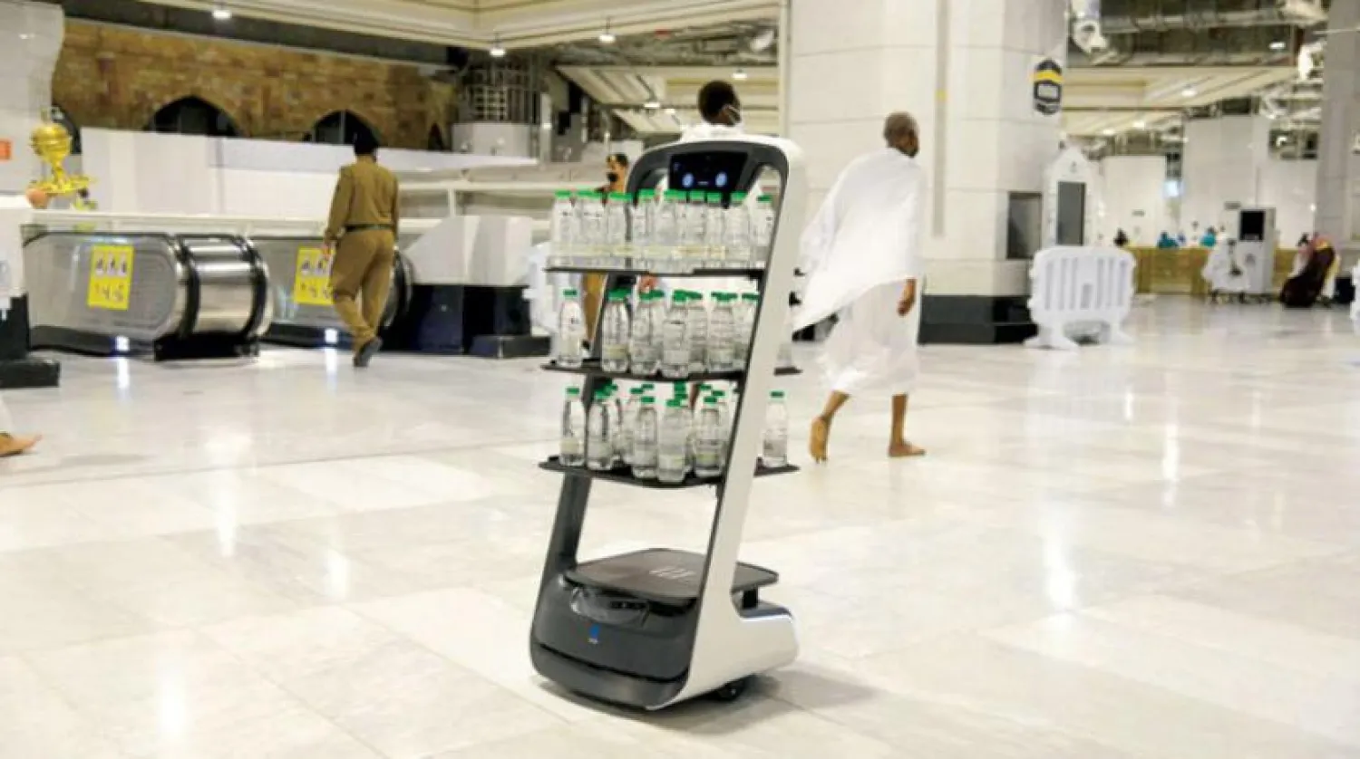 Robots distributing Zamzam water among the many robots that serve pilgrims and work on sterilization and other services (Asharq Al-Awsat)