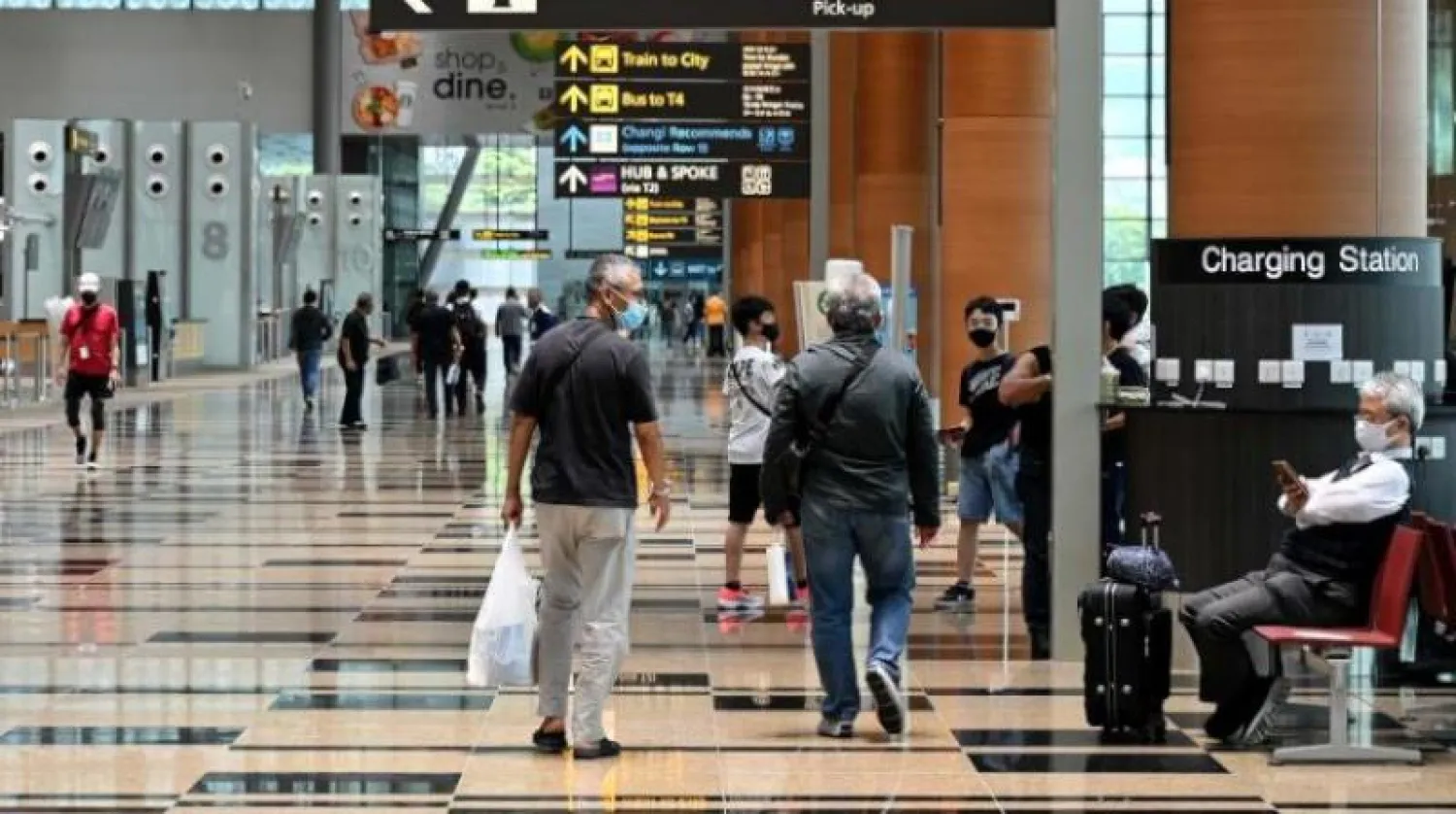 مسافرون في صالة المغادرة بمطار شانغي الدولي في سنغافورة (أ.ف.ب)