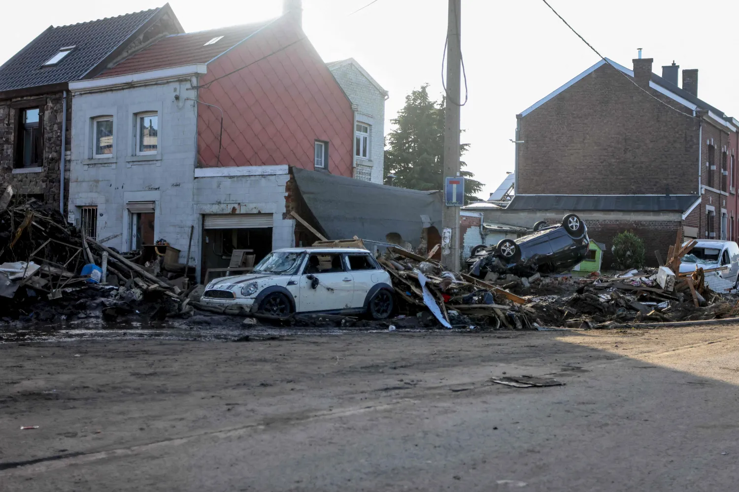 سيارات مدمرة وأنقاض مكدسة في أحد الشوارع في منطقة فو سو شيفريمون بلجيكا (أ.ف.ب)