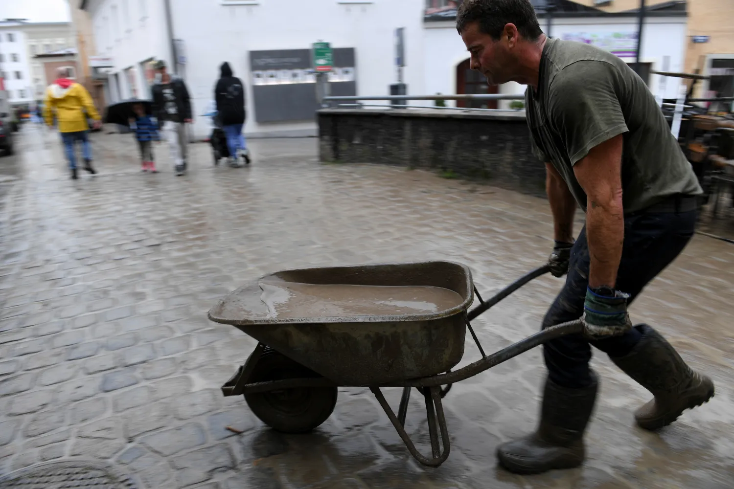 متطوع يزيل الطين من قبو غمرته المياه في هالين النمسا (رويترز)