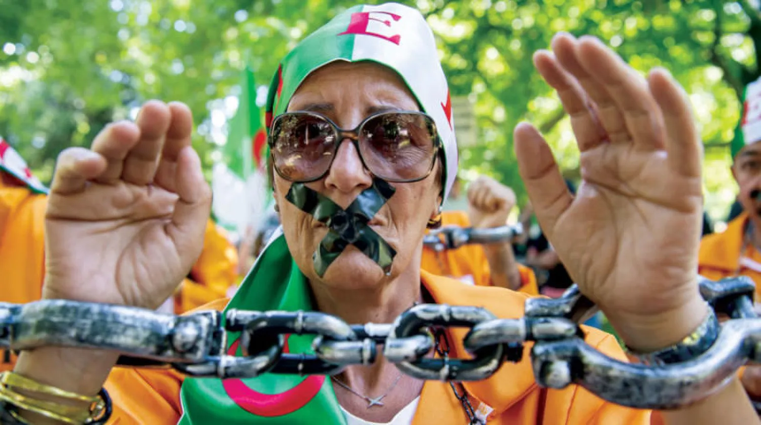 أحد المشاركين في مظاهرة بجنيف ضد تكميم أفواه الصحفيين في الجزائر (إ.ب.أ)